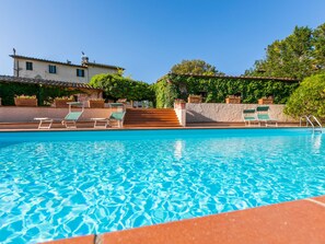 A clear swimming pool with lounge chairs and a stone wall. - Bardeggiano - Caterina 3 (COL246) by Interhome (Colle Val d'Elsa)
