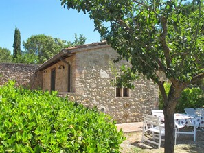 A stone building with a small window and a door, surrounded by greenery and a tree. - Antico Borgo S LorenzoAlbicocco by Interhome (Colle Val d'Elsa)