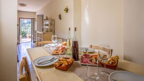 Une table à manger dressée avec des assiettes, des couverts, des verres et divers aliments.