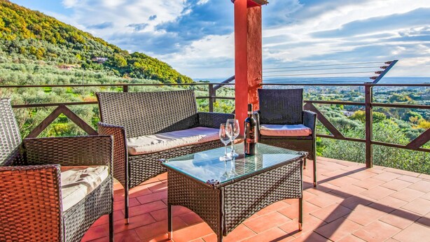 A terrace with wicker furniture and a glass table, overlooking a scenic landscape. - Francesco by Interhome (Montecatini Terme)