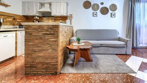 A modern living space with a kitchen, a grey sofa, and a decorative wall. - Apartment Viliam by Interhome (Rovinj)
