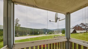 A room with a large window offering a view of a road, green fields, and distant buildings. - Horní Mísečky by Interhome (Horni Misecky)