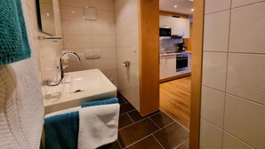 Une salle de bain moderne avec un lavabo, un miroir et un porte-serviettes.