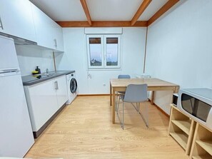Enjoy meals at the dining table, adjacent to a window with a city view.