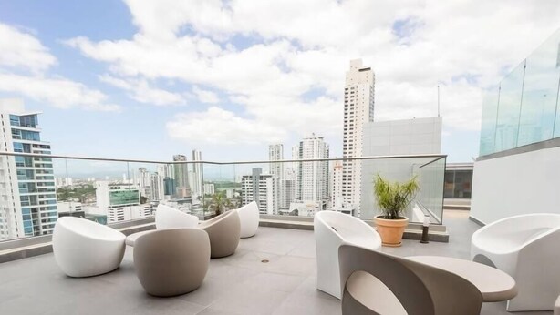 A modern rooftop terrace with contemporary seating and a city view.