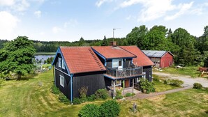 A two-story house with a red roof, a balcony, and a view of a lake. - Enerhögen Flädern by Interhome (Bullaren)