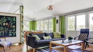Ein modernes Wohnzimmer mit einem dunklen Sofa, einem Holztisch und einem Streifen Teppich.