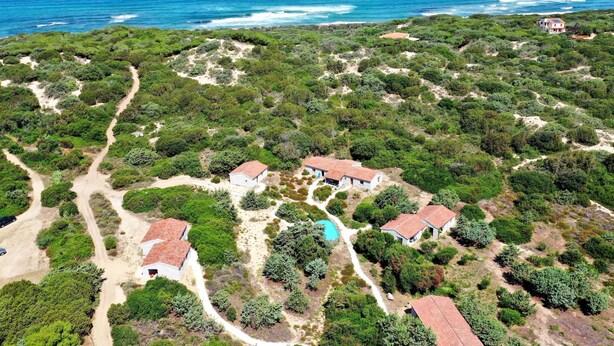 An aerial view of a coastal property with multiple buildings, a swimming pool, and a clear view of the ocean. - Mare di Ginepri (BAD115) by Interhome (Badesi)