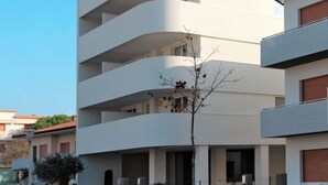 A modern multi-story building with a curved facade, balconies, and a clear sky. - Torre Bianca by Interhome (Lignano Sabbiadoro)