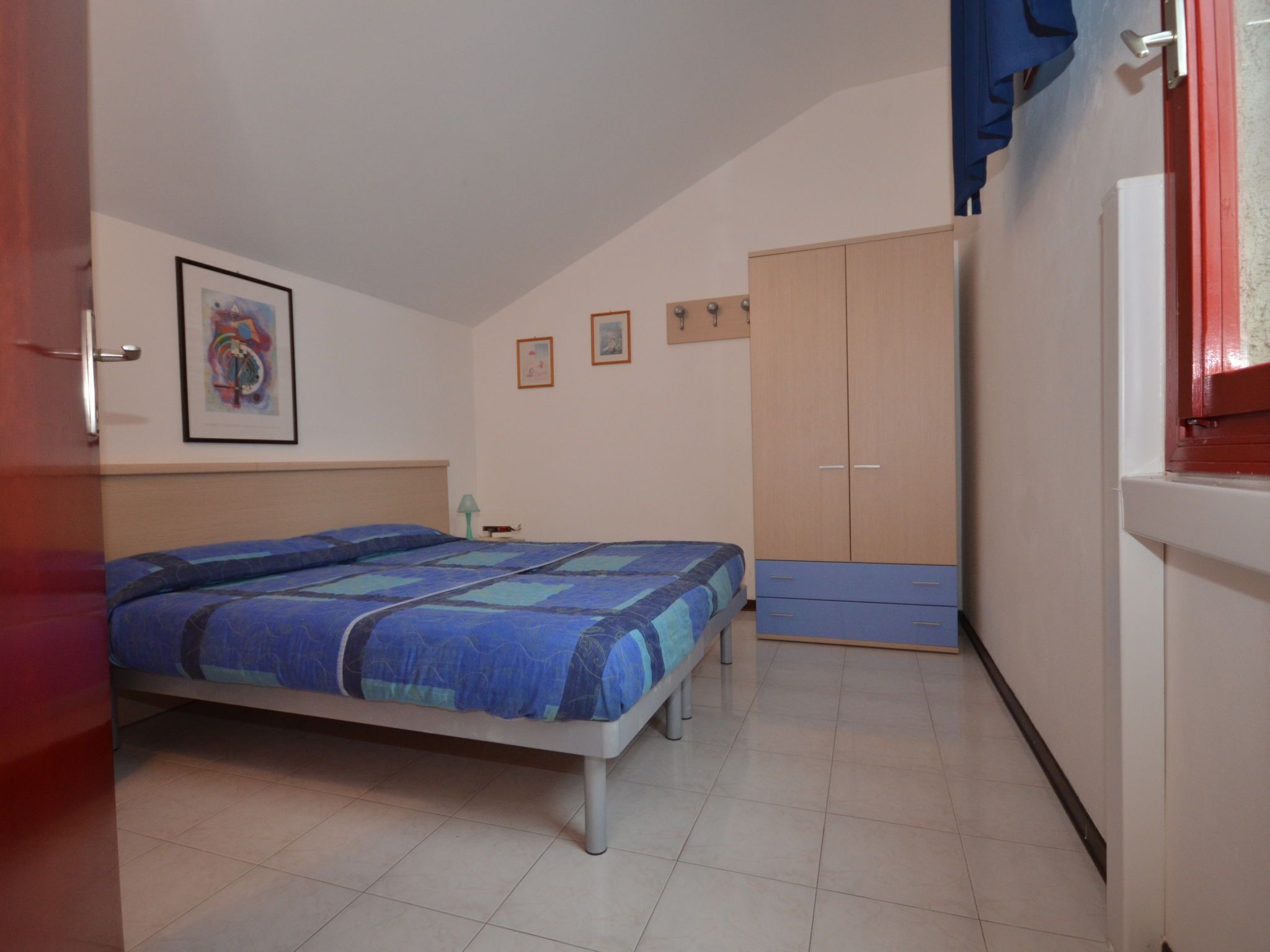 Une chambre à coucher avec un lit, une armoire et une porte.