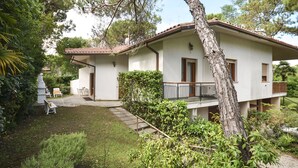 A two-story house with a balcony, surrounded by lush greenery and a well-maintained garden. - Villa Ralph by Interhome (Lignano Riviera)