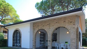 A building with a brick facade, arched doorways, and a patio area with outdoor seating.