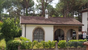 A building with a tiled roof, two arched doorways, and a satellite dish on the roof.