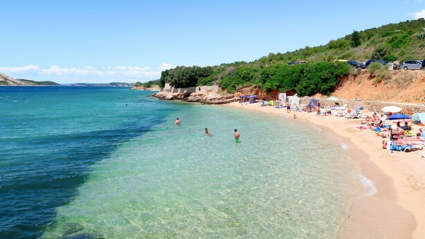 A beach with clear water, sandy shore, and greenery. - Apartment Matius by Interhome (Rab/Rab)