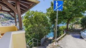 A staircase leading to a beach with a blue sign indicating a pedestrian path.