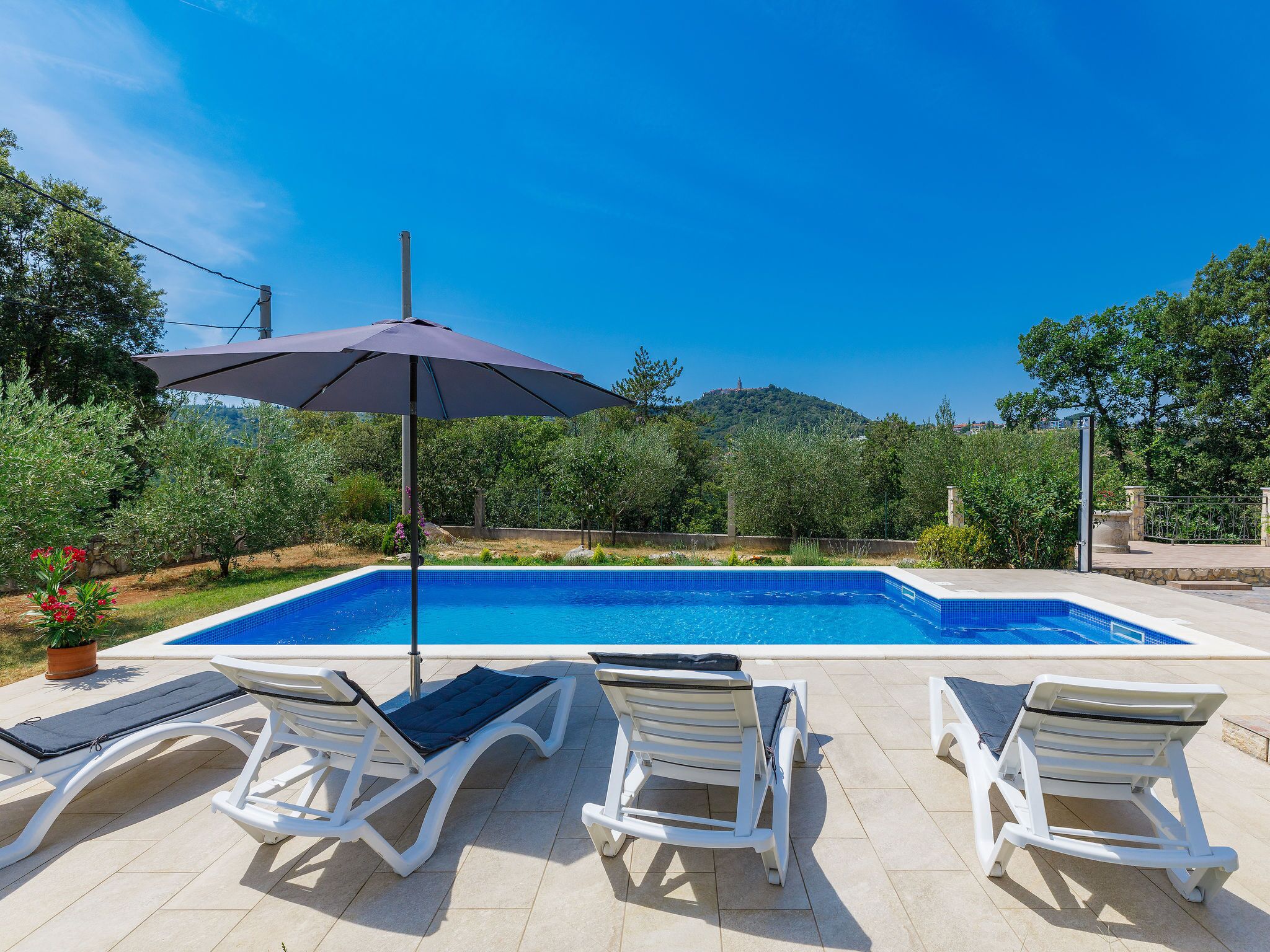 Ein Pool mit Liegestühlen und Sonnenschirm.