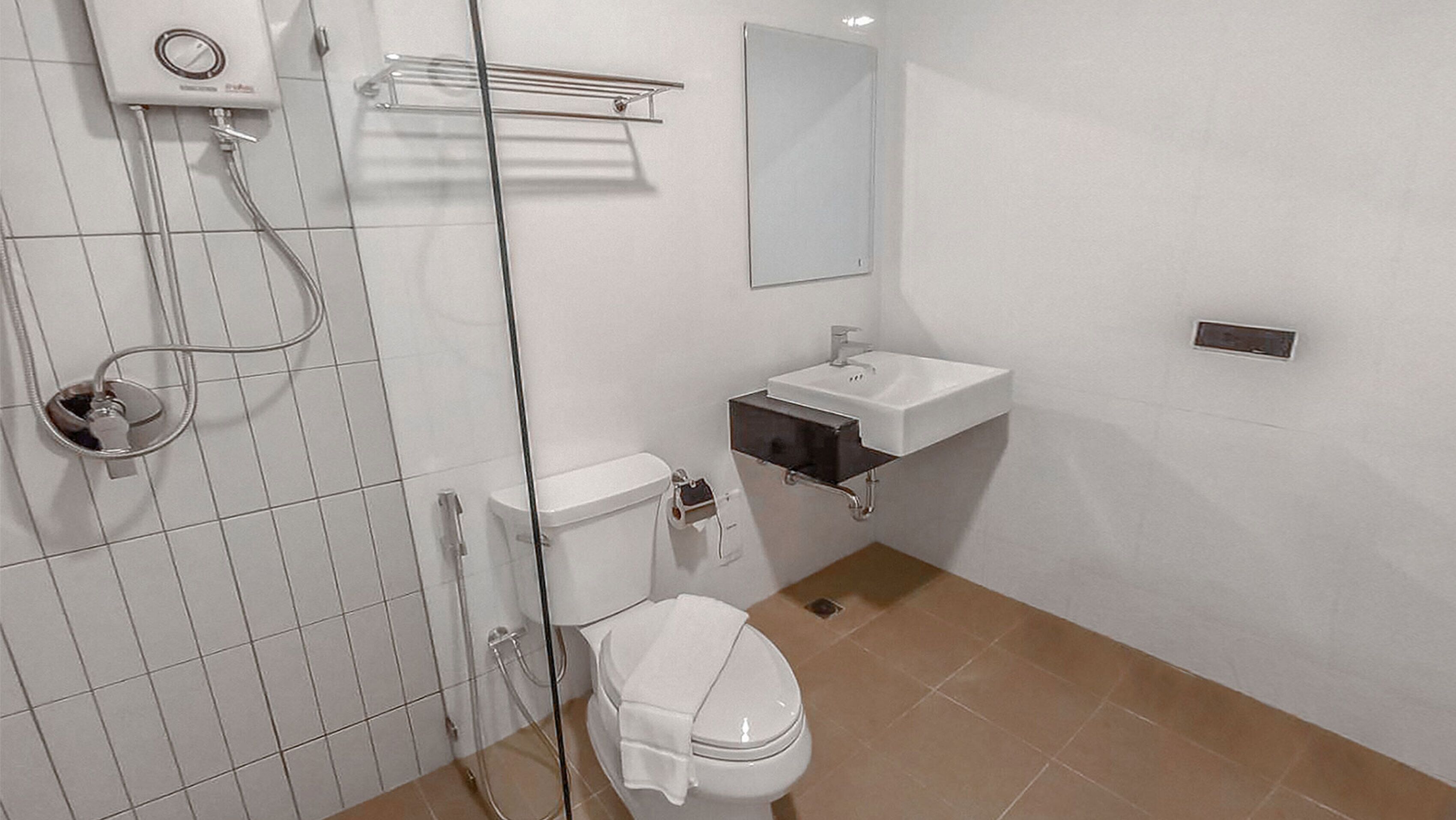 A modern bathroom with a toilet, a sink, and a shower.