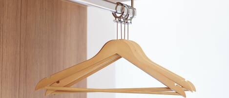 A wooden hanger suspended from a ceiling-mounted rod.