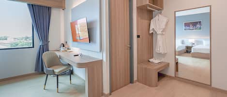 Une chambre d’hôtel équipée d’un bureau, d’une chaise et d’un lit.