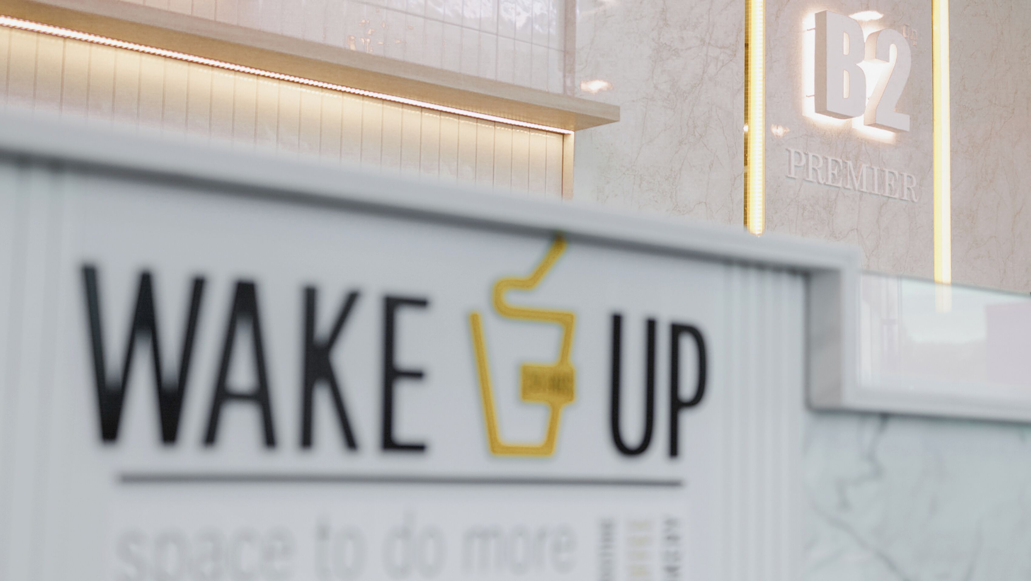 Un letrero con el texto 'WAKE UP' y un dibujo de una taza de café.
