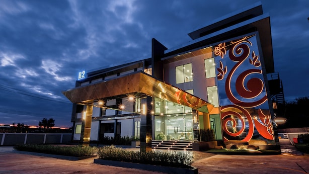 A modern building with a glass facade, a prominent spiral design on the exterior, and a sign indicating 'B2'. - B2 Udon Premier Hotel (Udon Thani)
