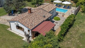 A residential property with a swimming pool, a patio with lounge chairs, and a garden. - Verbanac by Interhome (Labin)
