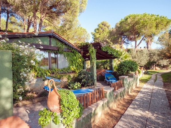 Ein Patio mit Pergola, Sitzgelegenheiten im Freien und einem Weg.