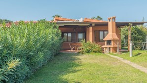 A modern house with a patio, a barbecue area, and a well-maintained garden. - Rei Marina Fronte Mare (REI204) by Interhome (Costa Rei)