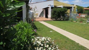 A modern house with a paved driveway, a covered patio, and a well-maintained lawn. - Mirto Marino (REI410) by Interhome (Costa Rei)