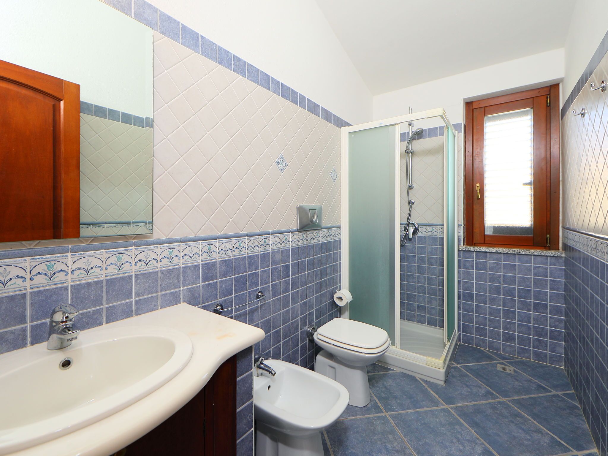 Une salle de bain équipée d’un lavabo, d’un bidet, de toilettes et d’une douche à parois de verre.