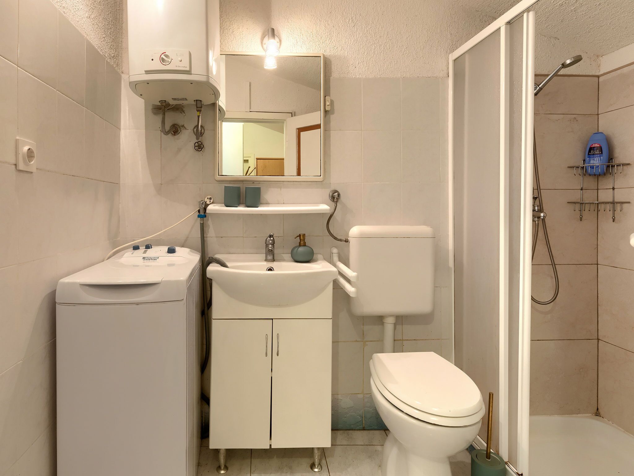 A bathroom with a toilet, sink, and shower.