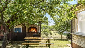 Ein Patio mit Kamin aus Ziegelsteinen, zwei Holzbanken und einer Steinmauer.