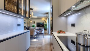 A modern kitchen with a marble countertop, stainless steel appliances, and a dining area with a TV and plants. - Vacation home Sara by Interhome (Poreč/Kaštelir)