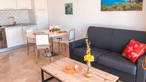 Un salon moderne comprenant un canapé, une table basse et un coin repas avec une table et des chaises.