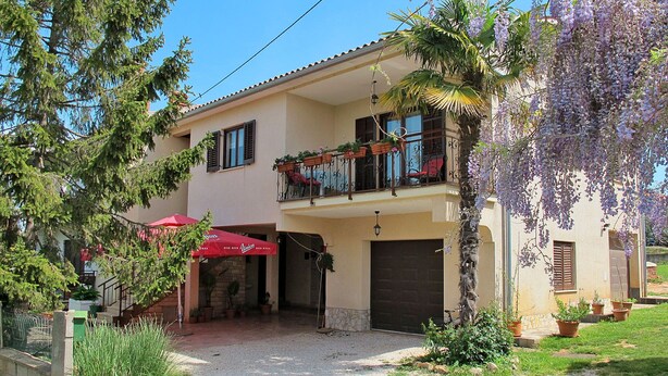 A two-story building with a balcony, a gravel driveway, and potted plants. - Apartment Kuki by Interhome (Poreč)