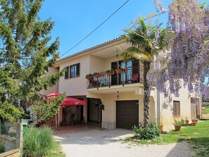 A two-story building with a balcony, a gravel driveway, and potted plants. - Apartment Kuki by Interhome (Poreč)
