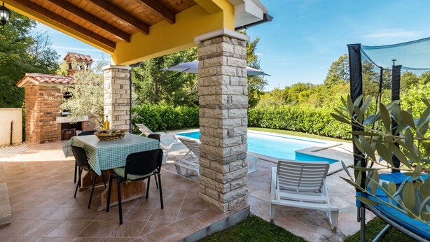 A covered patio with a pool, stone pillars, a brick barbecue, and outdoor seating. - Vacation home Antoni by Interhome (Pićan)