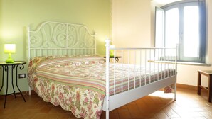 A bedroom with a bed, a nightstand, a lamp, a window, and a view of the outside. - Il Podere del Lago (BOL253) by Interhome (Lago di Bolsena)