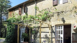 A rustic building with a wooden pergola, a potted plant, and a bench. - Podere Sant' Antonio (BOL213) by Interhome (Lago di Bolsena)