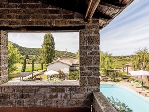 A stone structure with a pool and a view of a rural landscape.