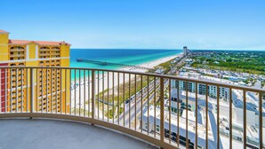 Ein Balkon mit Blick auf einen Strand, einen Steg und eine Skyline.