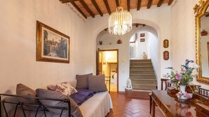 A bedroom with a bed, a dresser, a mirror, and a chandelier. - Alighiero II by Interhome (Boccheggiano)