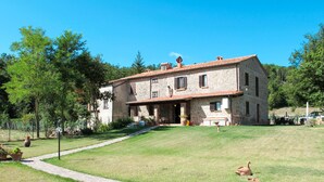 A stone house with a tiled roof, a paved pathway, and a grassy lawn. - Alighiero II by Interhome (Boccheggiano)