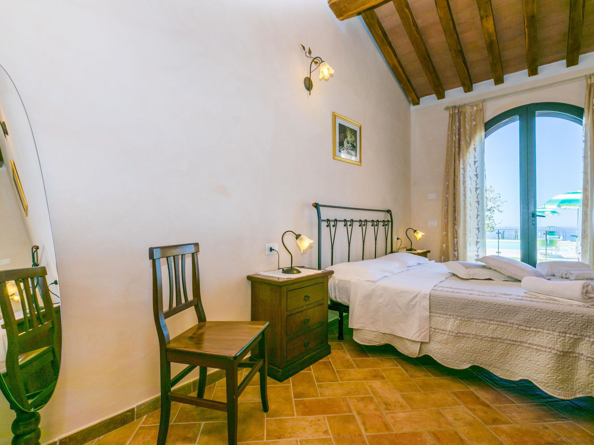 Ein Schlafzimmer mit Bett, Stuhl, Nachttisch und Kommode.