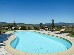 A swimming pool with lounge chairs and a view of distant hills. - Le Colmate by Interhome (Guardistallo)