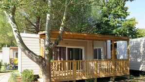 A mobile home with a wooden deck and a covered porch. - Campeggio del Forte by Interhome (Marina di Bibbona)