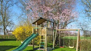 A playground with a slide, swings, and a climbing structure. - Apartment Harms by Interhome (Horumersiel)