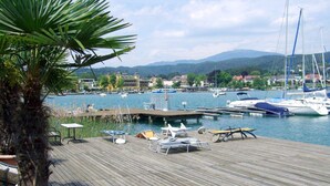 Un port de plaisance avec des bateaux amarrés, une terrasse en bois et un palmier.