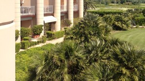 Een hotel met meerdere cilindervormige torens, een verzorgd gazon en diverse tropische planten.