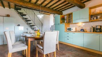 Een koelkast, een vaatwasser, kookgerei, borden en bestek, een eettafel